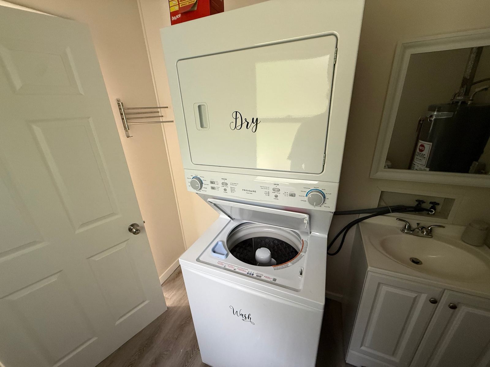 Stacked washer and dryer beside the half bath